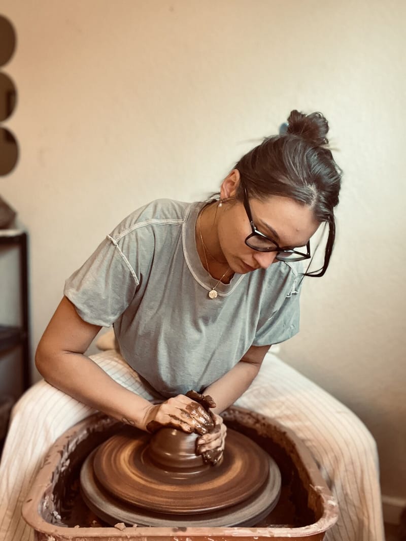 Paige throwing a pot on the wheel